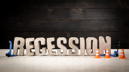 RECESSION Text with Traffic Cones and Forklift Toy on Desk