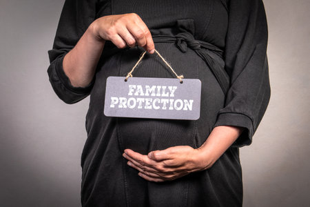 Pregnant Woman Holding Family Protection Sign for Maternity and Parental Care Conceptの写真素材