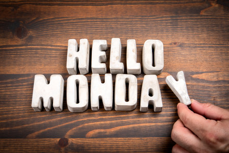 Hello Monday. Concrete alphabet letters and coffee mug on dark wooden texture backgroundの写真素材
