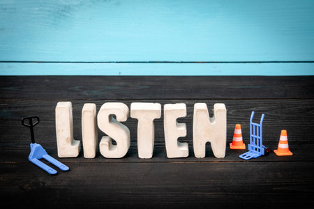 Listen. Concrete alphabet letters on a blue and black wooden backgroundの写真素材