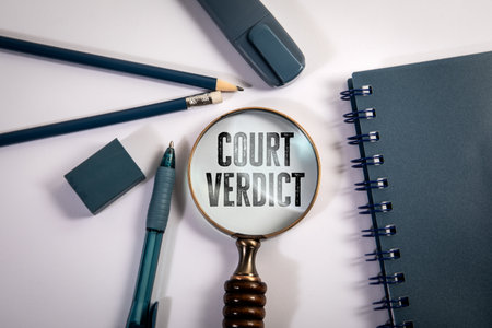 Court Verdict Text Under Magnifying Glass with Office Supplies on White Background