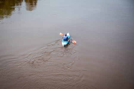 Solo Kayaker Paddling on Calm River Surface in Outdoor Adventure Setting