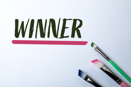 Winner Concept with Colorful Paintbrushes and Handwritten Text on White Backgroundの写真素材