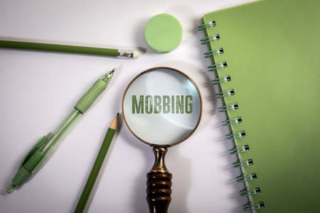 Mobbing. Text Under Magnifying Glass with Green Stationery on White Backgroundの写真素材