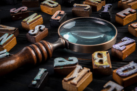 Vintage Letters and Magnifying Glass on Black Wooden Background for Research or Analysis Conceptの写真素材