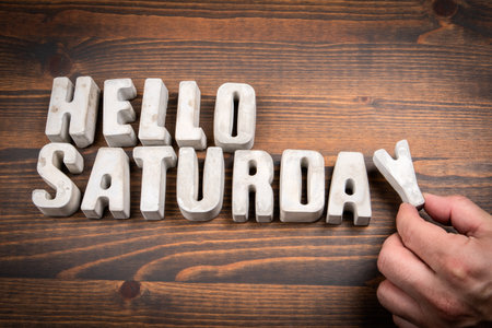 Hello Saturday Concept with Concrete Letters on Wooden Background