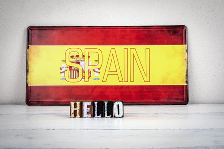 Hello Message with Wooden Letters in Front of Spanish Flag