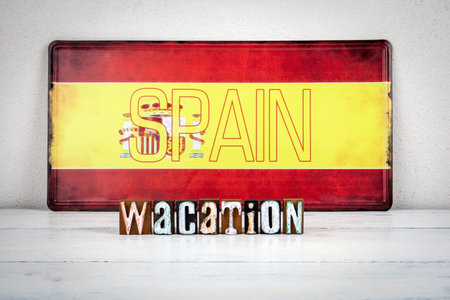 Spain Vacation Concept with Wooden Letter Blocks and Flag Background
