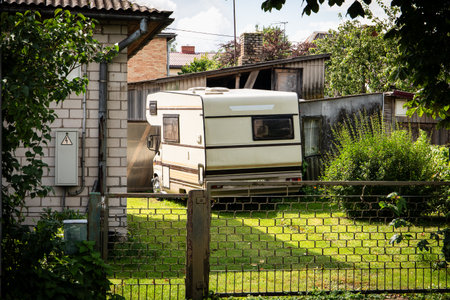 Retro Camper Van Parked in Residential Backyard on a Sunny Summer Dayの写真素材
