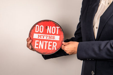 Businessman Holding Do Not Enter Myths Warning Sign Against False Informationの写真素材