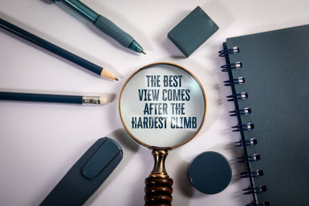 Motivational Quote Through Magnifying Glass Surrounded by Blue Stationery on White Desk