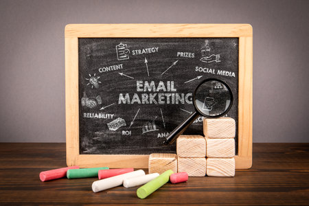 Email Marketing Strategy Concept on Blackboard with Icons, Magnifier and Chalk Elementsの写真素材