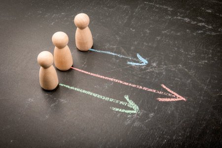 Three people figures choosing different paths represented by arrowsの写真素材