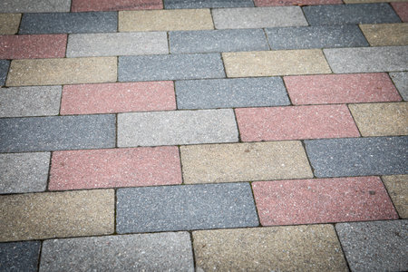 Colorful Paving Stone Pattern on Urban Sidewalk with Concrete Texture and Geometric Arrangement