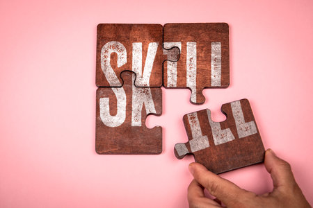 Skill Concept. Hand placing last wooden puzzle piece on pink background