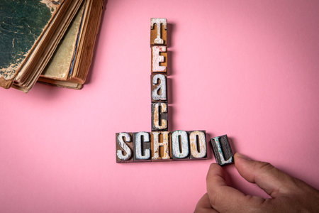 Teach and School Concept. Vintage wooden letter blocks on a pink background