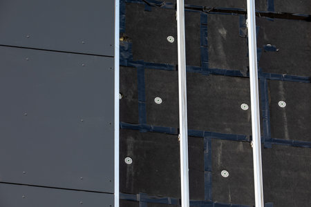 Modern building wall under construction, showing insulation layers, fastening elements, metal...