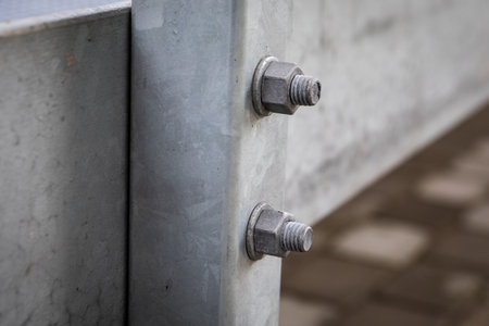 Close up of galvanized steel beam connection with visible bolts and nuts showing industrial construction detailの写真素材