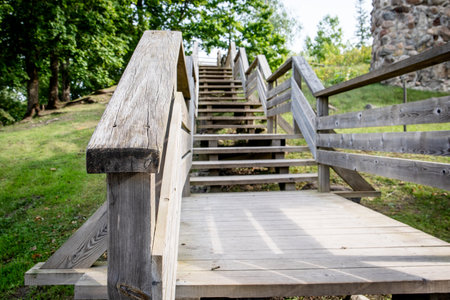 Rustic wooden staircase with railings leading uphill in a natural park settingの写真素材