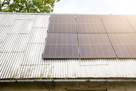 Modern solar panels mounted on an old corrugated metal roof, representing renewable energy