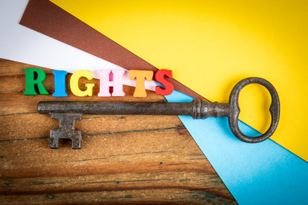 Creative symbolic image showing the word rights in colorful wooden letters beside an old vintage keyの写真素材
