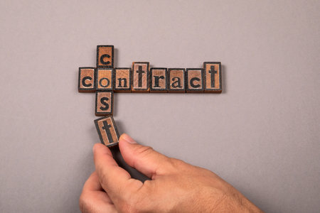 Cost And Contract Concept With Wooden Letter Blocks And Hand