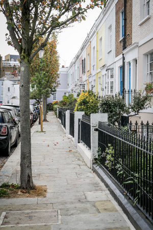 Colorful Residential Street with Iron Fence and Treesの写真素材