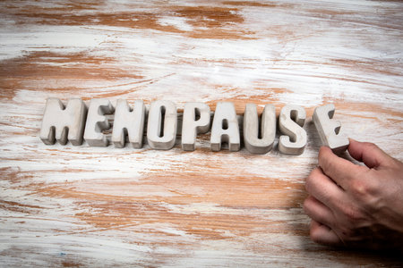 Word menopause written with concrete letters on wooden background symbolizing women health aging and hormonal change conceptの写真素材