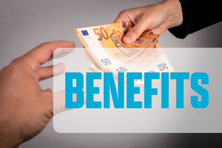 Hands Exchanging Euro Banknotes with Benefits Text Representing Financial Support and Monetary Assistance Conceptの写真素材