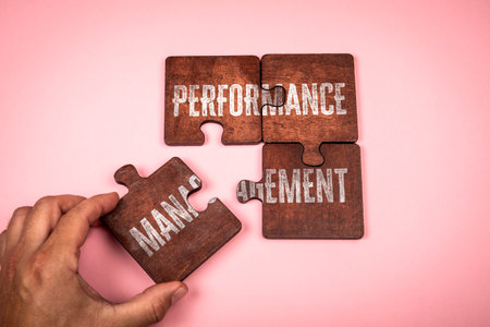 Hand Completing Puzzle with Words Performance Management Representing Business Improvement and...
