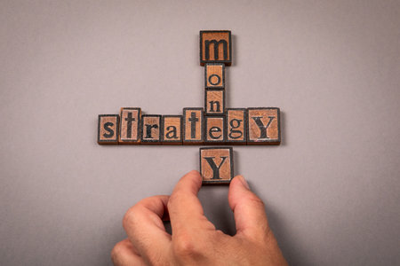 Words Money and Strategy Formed with Vintage Wooden Letter Blocks Representing Financial Planning and Business Conceptの写真素材