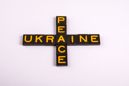 Word Peace and Ukraine Forming Cross Shape with Yellow Letters on White Backgroundの写真素材