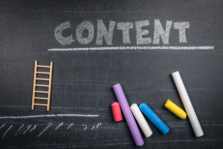 Word Content Written on Blackboard with Colorful Chalk and Small Wooden Ladder Symbolizing Creativity and Growthの写真素材