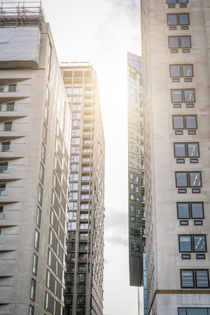 Modern high rise buildings with glass and concrete facades illuminated by sunlight in city centerの写真素材