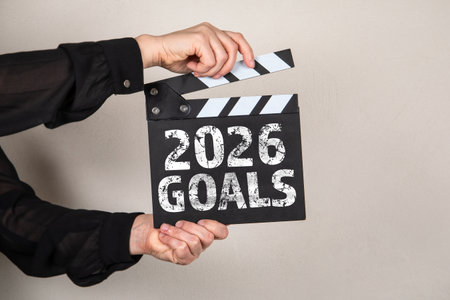 2026 Goals. Film Clapperboard in womans hands on light background