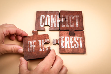 Conflict of Interest Concept with Wooden Puzzle Pieces and Handsの写真素材