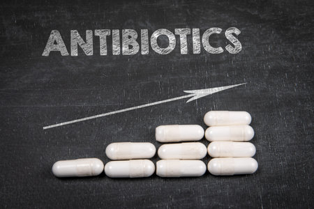 Antibiotics Treatment Progress Concept With Capsules On Chalkboard Background