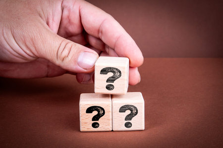 Question Marks Concept With Hand Stacking Wooden Blocks