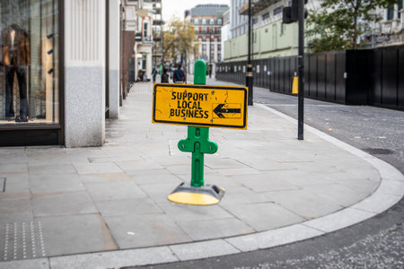 Support Local Business Sign on City Street With Direction Arrow