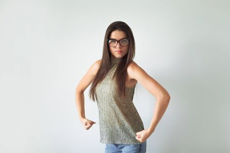 annoyed indignant housewife, raises her hands into fists, shows strength, comic, joke. wears round...