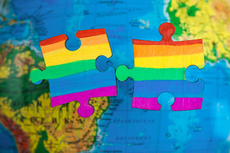 LGBT as a part of society - one puzzle with the coloring of the flag of sexual minorities on a blue...