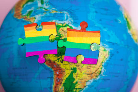 LGBT as a part of society - one puzzle with the coloring of the flag of sexual minorities on a blue globe backgroundの写真素材