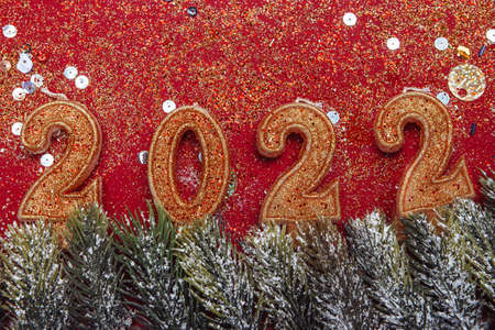 2022 decorative figures of the new year and Christmas, golden candles on a red background. frame of spruce branches. banner, Christmas card,の写真素材