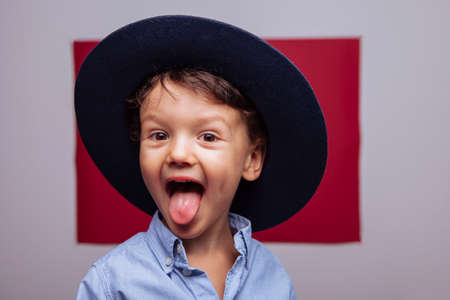 a happy preschool child is trained online on a laptop and does homework in a notebook. A cute,...