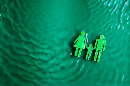 a symbol of the family, mom dad and baby on a green background of water ripples.の写真素材