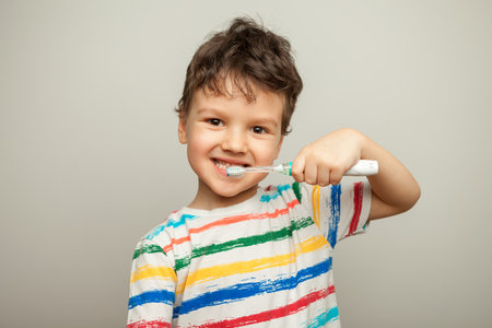 the child brushes his teeth. a boy with a toothbrush in his hands shows how to brush his teeth.の写真素材