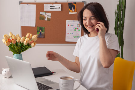 Happy casual beautiful woman working on a laptop.の写真素材