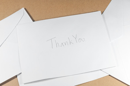 wording thank you of white envelope on brown backgroundの写真素材