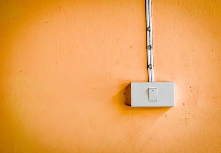 Electronic switch on orange color wallの写真素材