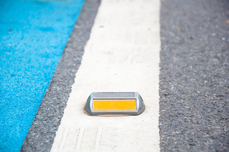 Close up of reflector or stud on asphalt roadの写真素材